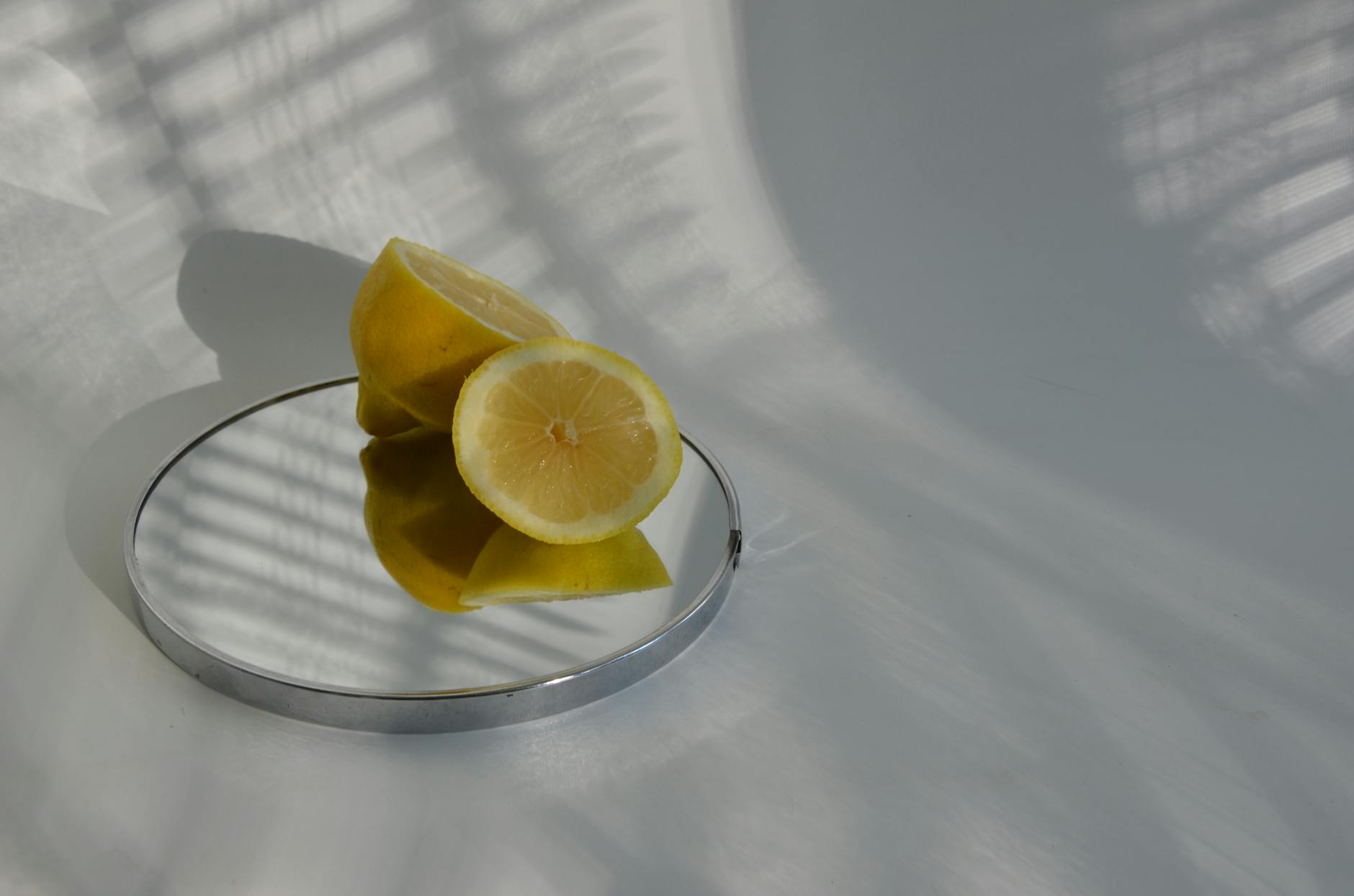 A hand holding a fresh lemon against a bright yellow background, symbolizing renewed energy and sensation