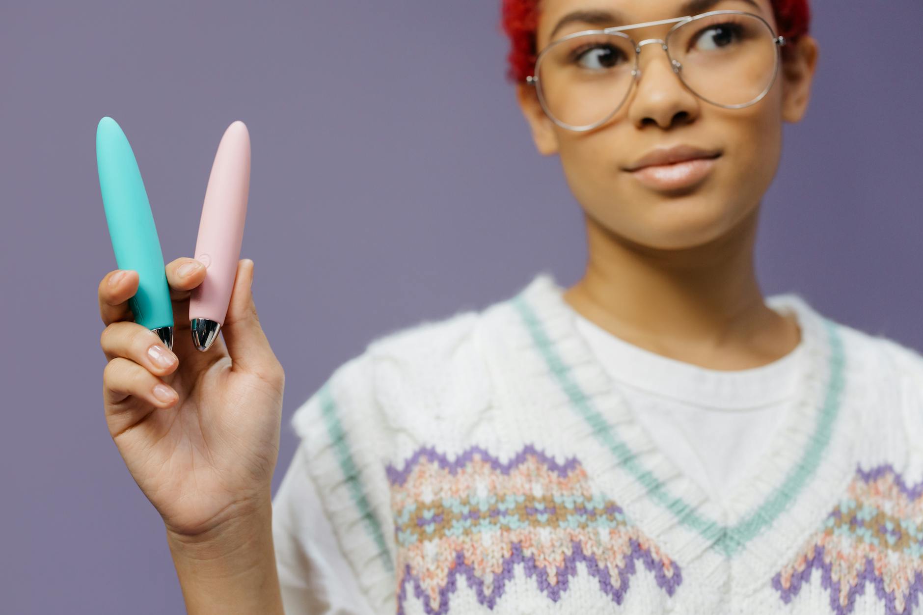 Woman holding colorful vibrators, representing reclaiming pleasure and personal agency